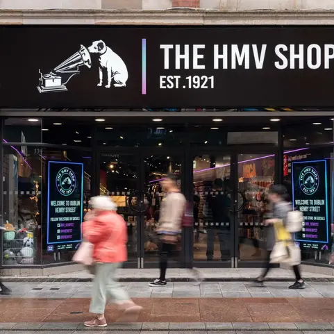 a store front with people walking on the sidewalk