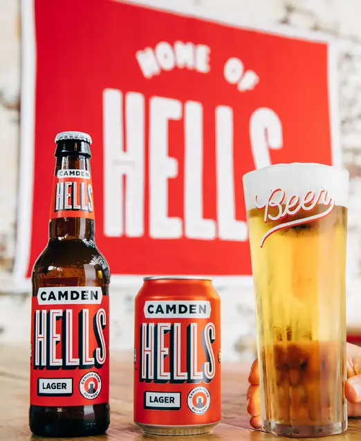 a hand holding a beer and a can