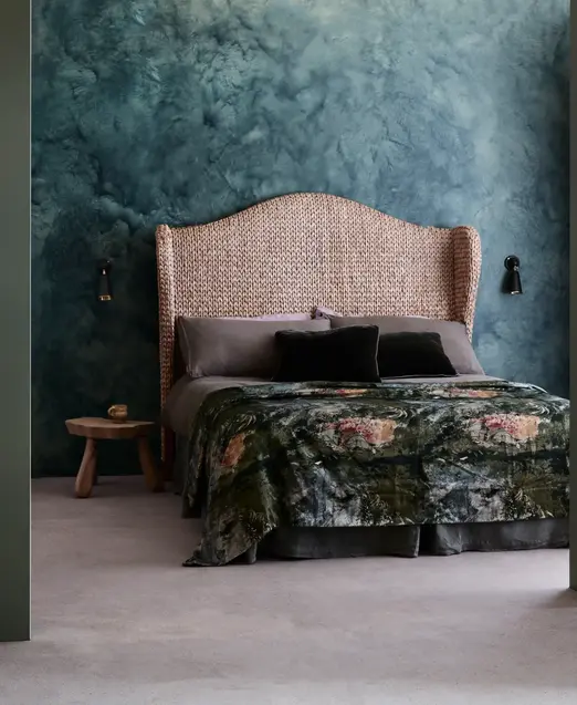 a bed with a wicker headboard and a table